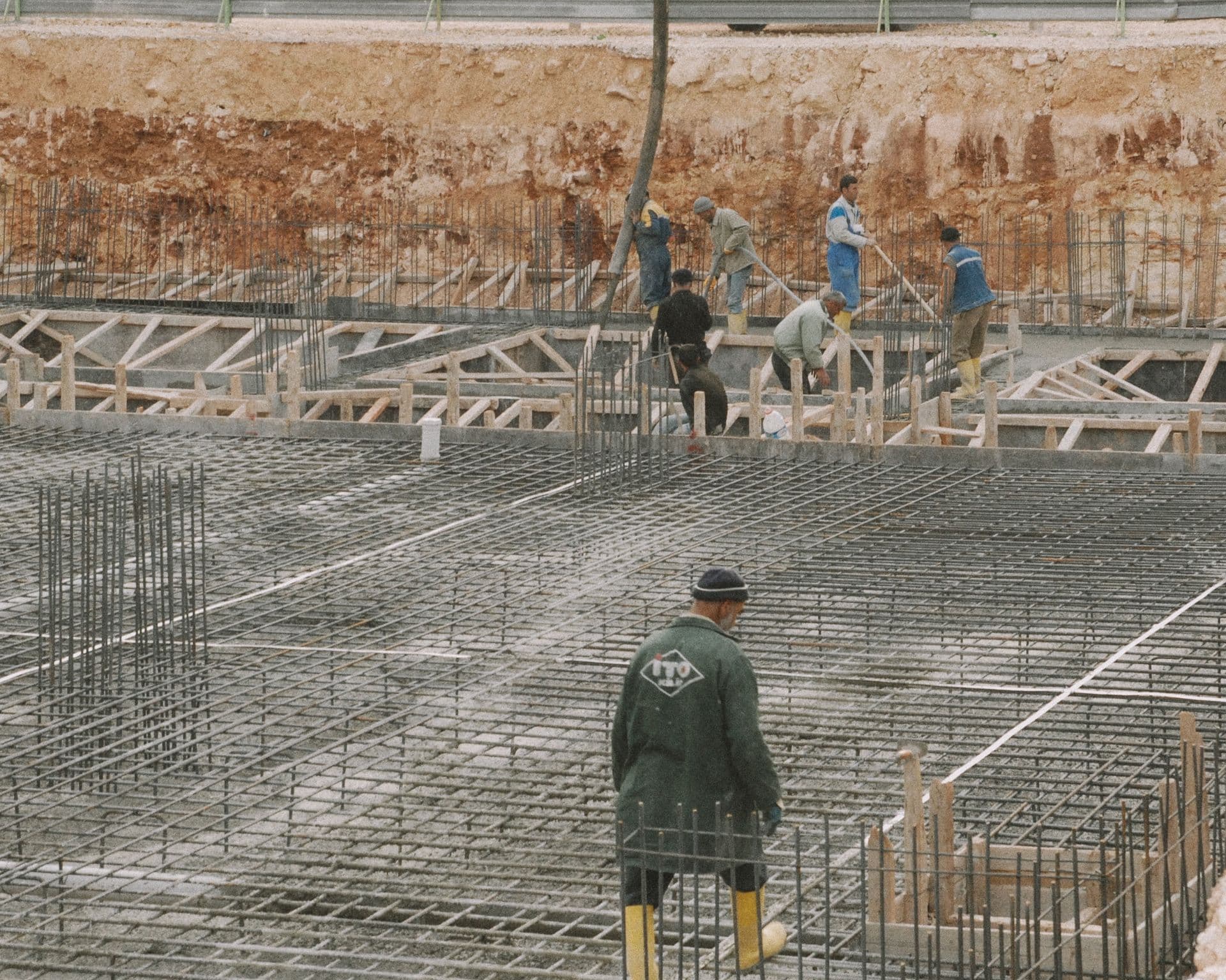 Equipe executando armação de aço e fôrmas para fundação em concreto