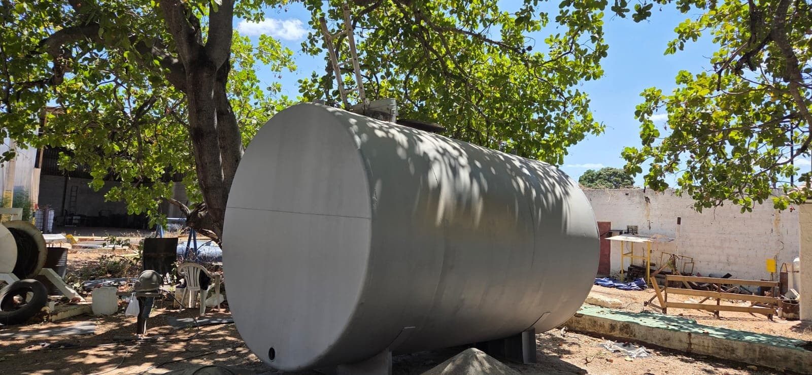 Tanque metálico horizontal com superfície clara em área externa